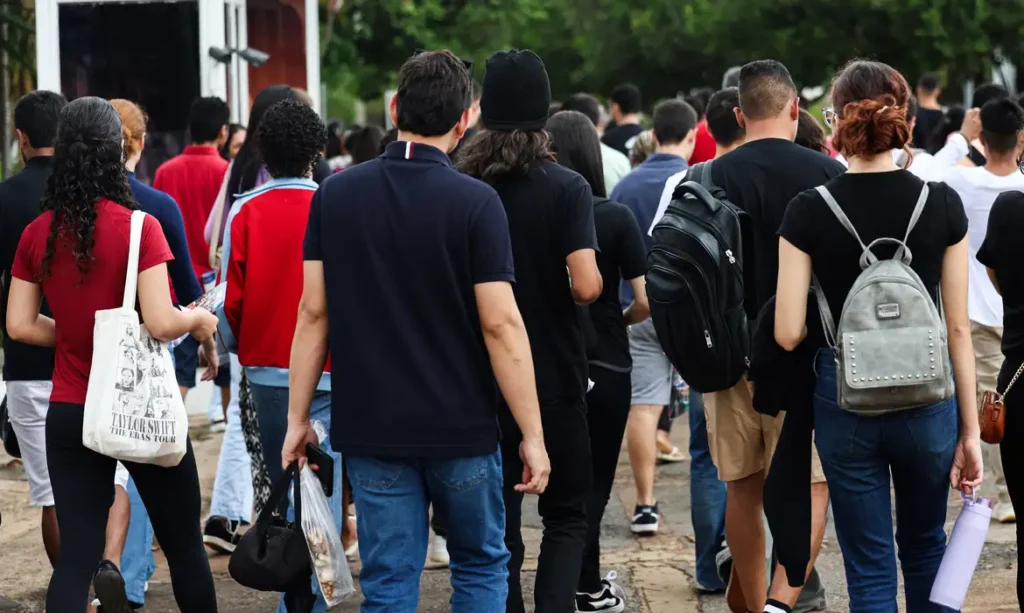 #PARA TODOS VEREM: Enem 2025, imagem mostra alunos dirigindo-se as salas de provas.
