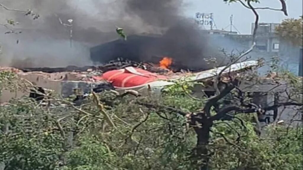 #PARA TODOS VEREM: Queda de avião, aeronave em chamas ao solo, com um entulho de destroços e muita fumaça.